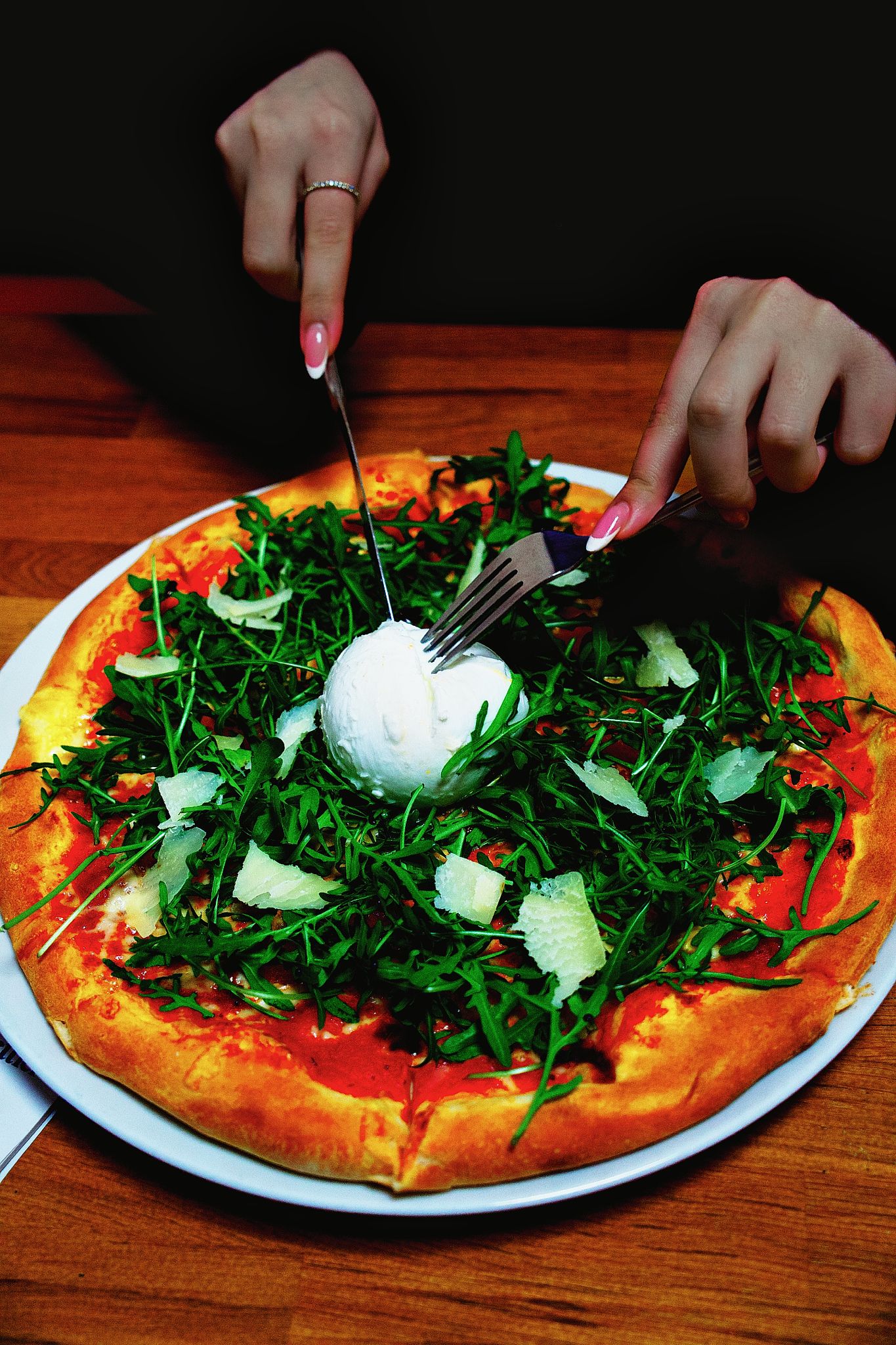 Frisch zubereitete Pizza mit Burrata, Rucola und Parmesan